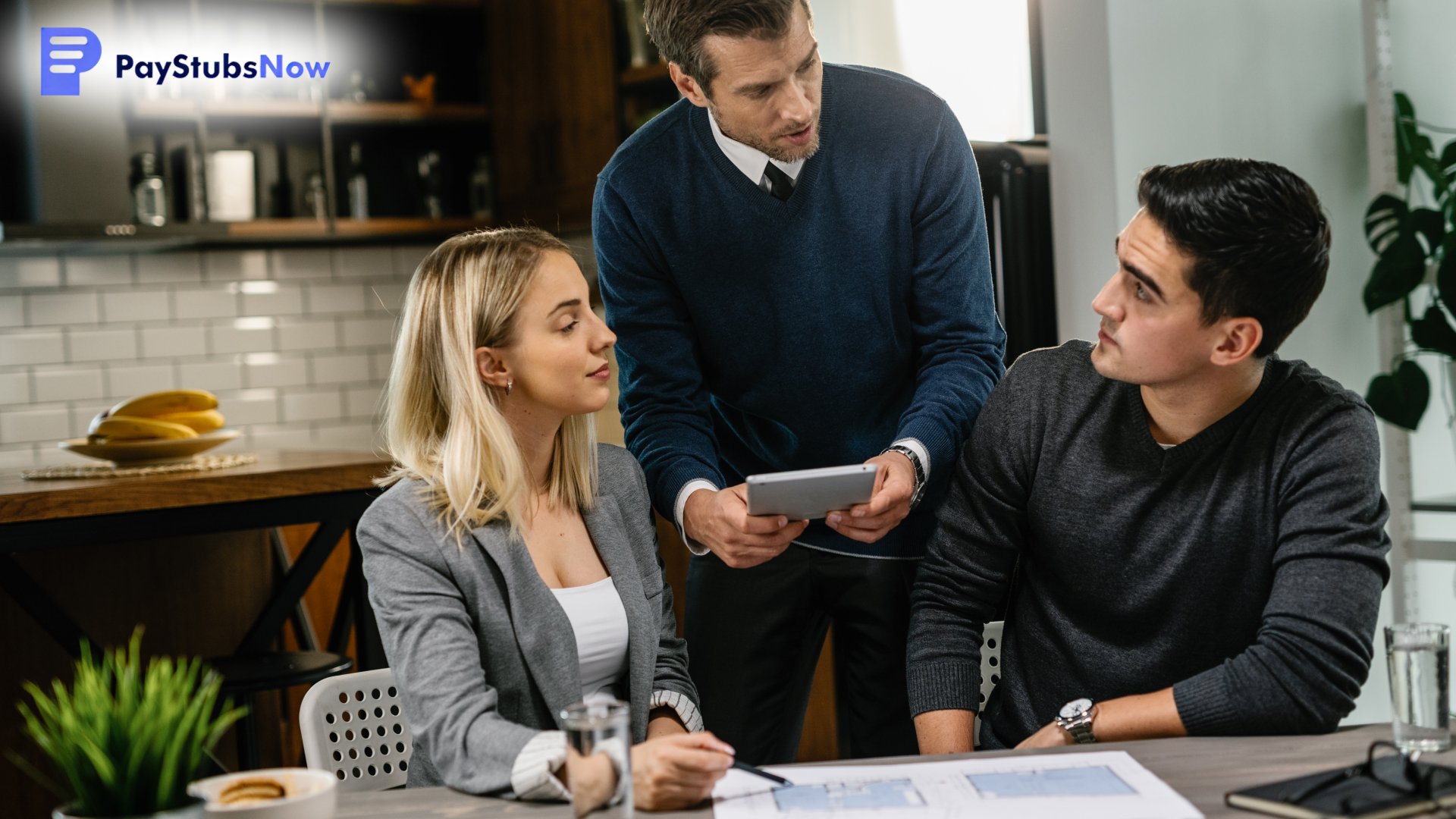 A financial advisor meets with two people, holding a tablet while they review a document on the table