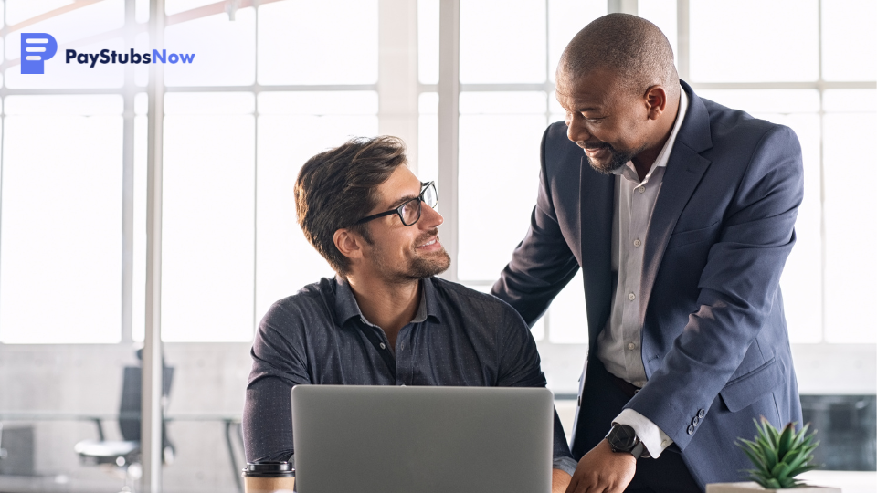 Two people look at a computer in an office setting